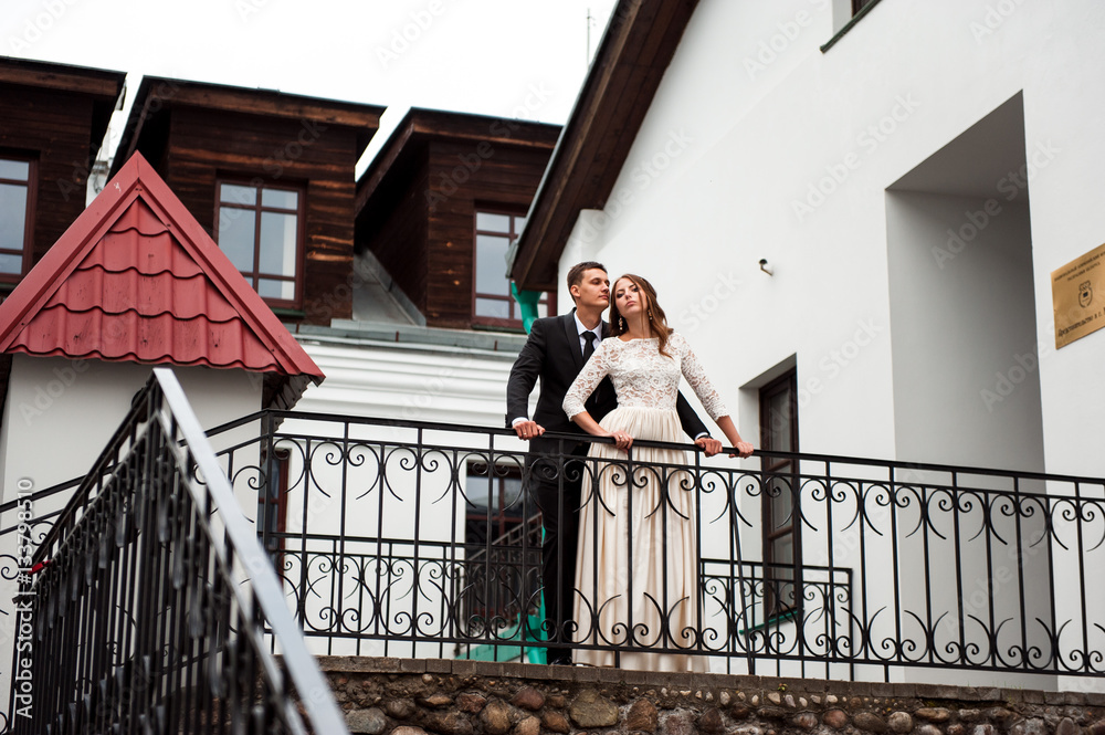 gorgeous happy wedding couple walking and kissing in the old city of Minsk, Belarus gorgeous happy wedding couple walking and kissing in the old city of Minsk, Belarus