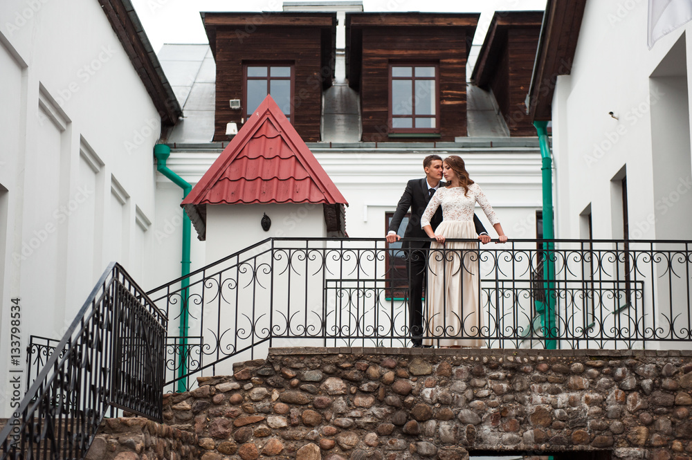 gorgeous happy wedding couple walking and kissing in the old city of Minsk, Belarus gorgeous happy wedding couple walking and kissing in the old city of Minsk, Belarus