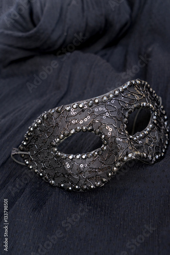 View of festive mask on black silk background