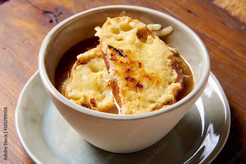 Serving of onion soup, toast and melted cheese Serving of onion soup, toast and melted cheese