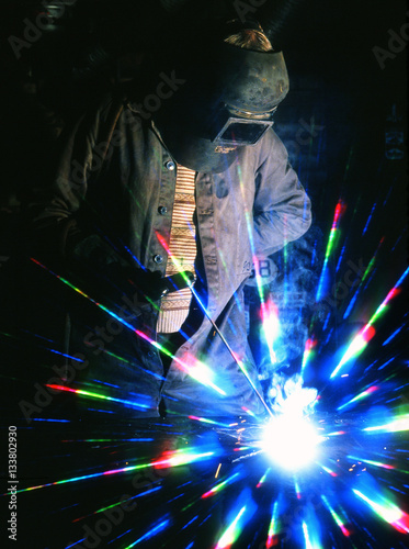 Man using electric arc welding equipment with effect filter on camera lens. © Paul