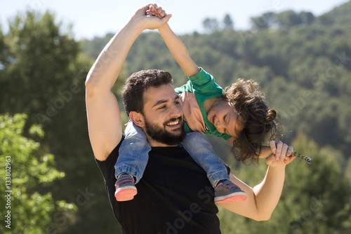Father and baby girl playing outdoors photo