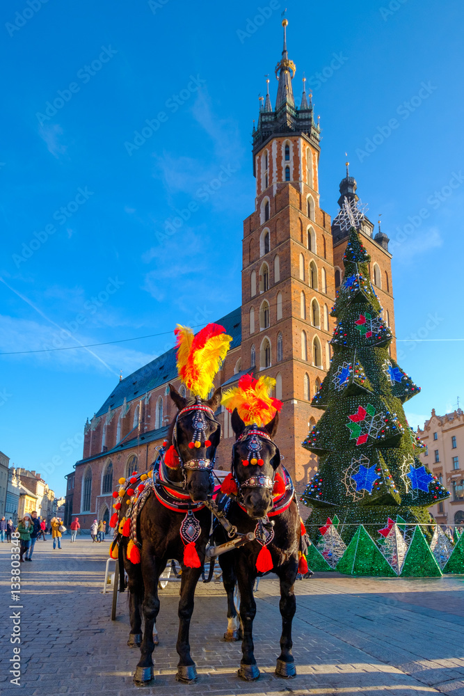 Φωτογραφία Carriages for riding tourists on the background of Mariacki cathedral at main sq