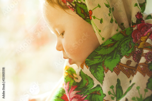 Portrait of a pretty little girl in a traditional Russian scarf