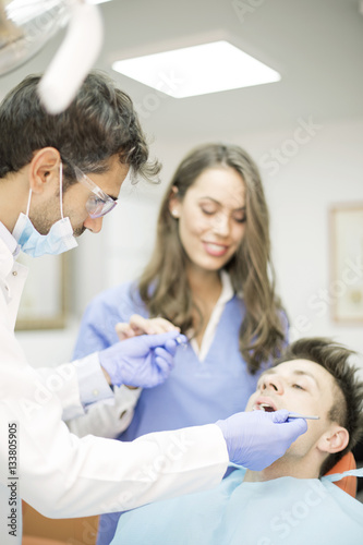 Young man having dental chekup at dentist office