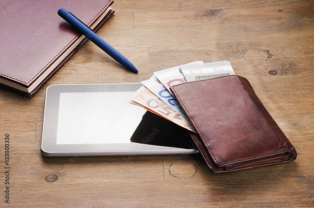 money, tablet and notebooke on table money, tablet and notebooke on table