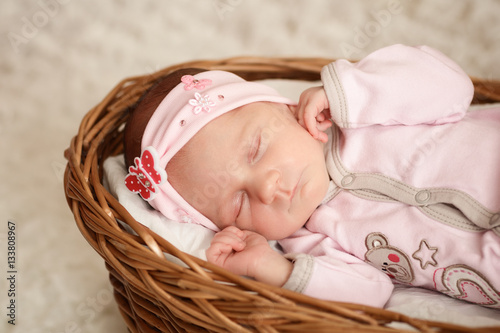 Newborn baby girl sleeping in basket