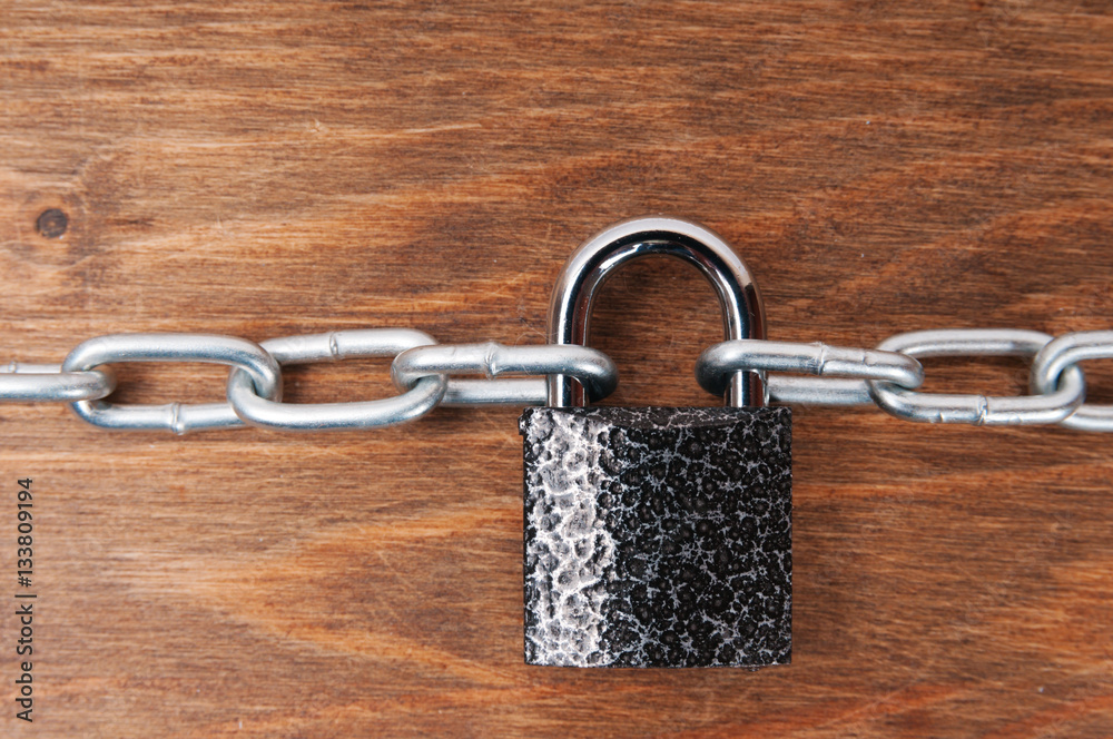 Wooden surface with chains and lock, concept of security Wooden surface with chains and lock, concept of security