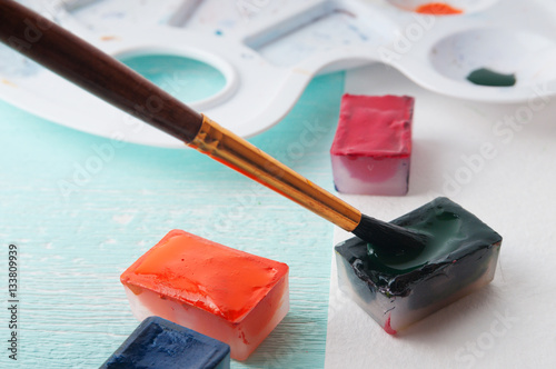 A man takes a brush watercolor paint before painting