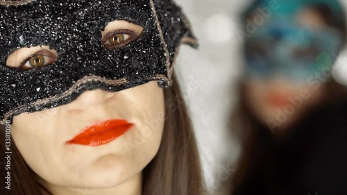 Beautiful woman in black, carnival mask looking to the camera, steadycam shot
 photo