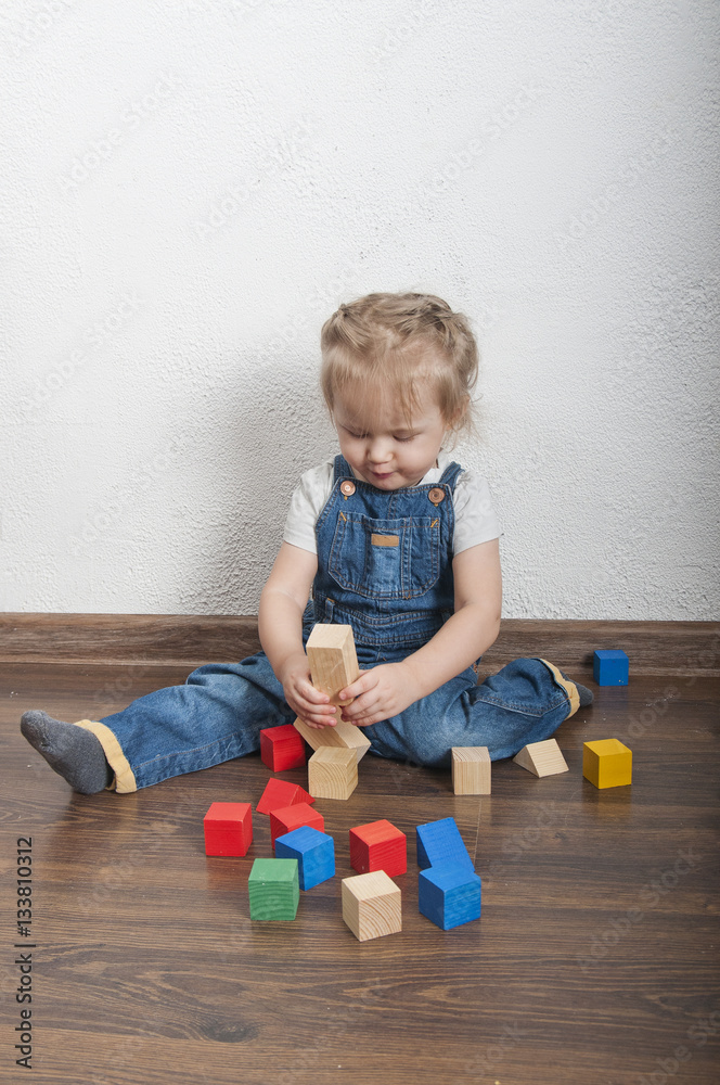 Little cute girl playing with a wooden constructor Little cute girl playing with a wooden constructor