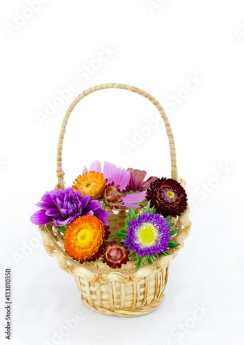 summer coloeful flowers bouquet in wicket basket isolated photo