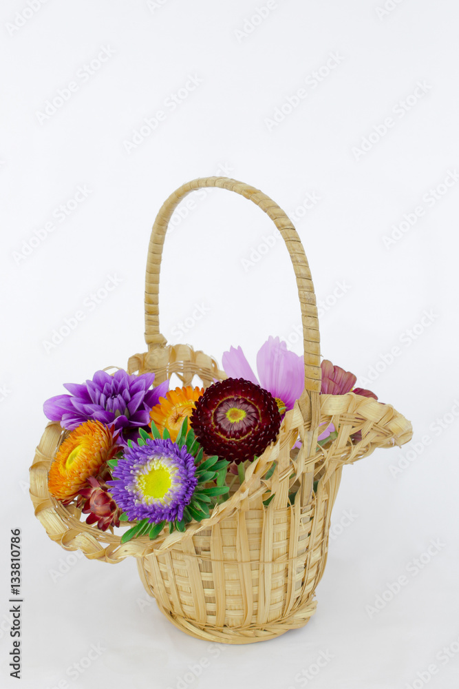 summer coloeful flowers bouquet in wicket basket isolated in white background