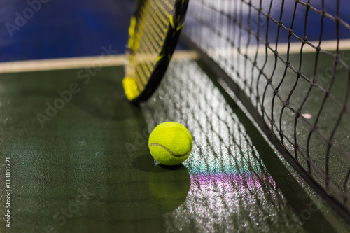 Tennis ball, racquet and net on wet ground after raining © Hanoi Photography