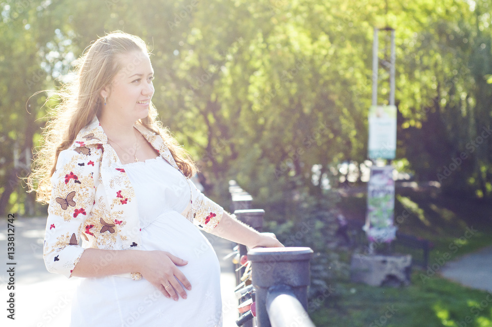 Naklejka premium young pregnant woman in the summer park