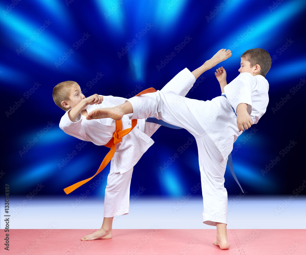 Children athletes beat kicks on a bright blue background