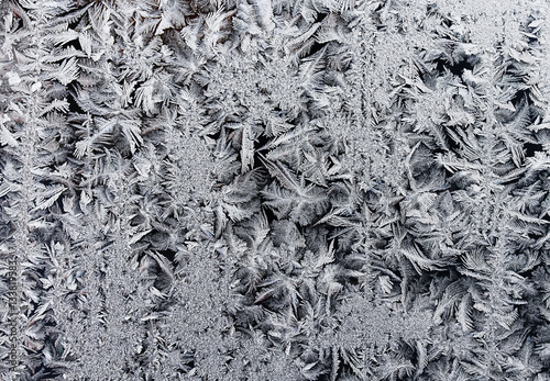 winding rows of frost of ice crystals on winter glass
