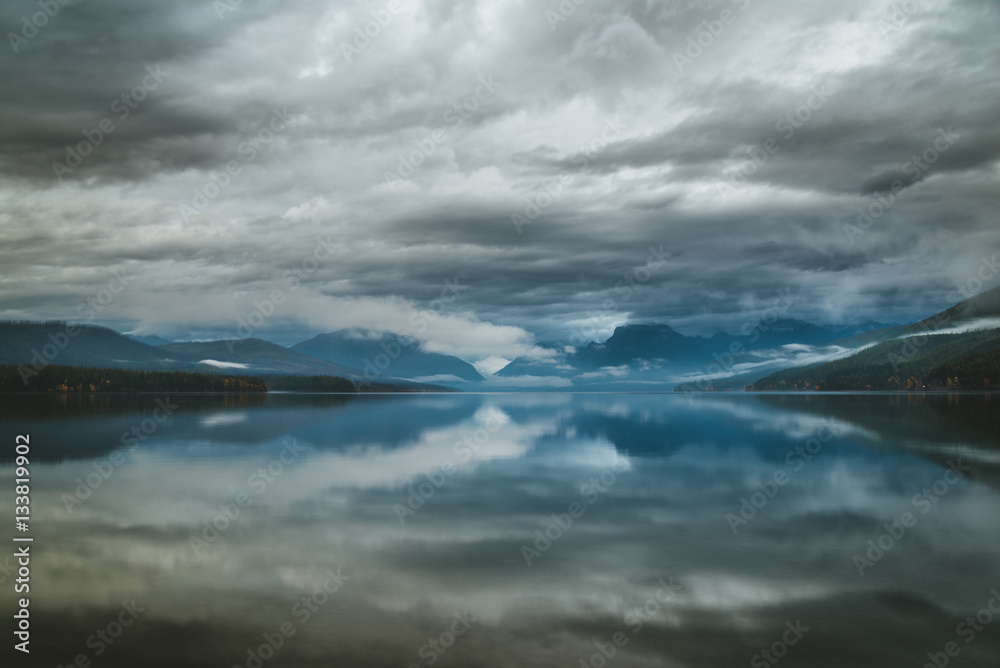 Overcast skies reflected in a calm lake.