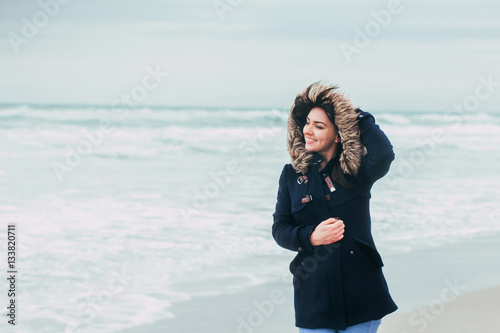 The girl on the background of the sea in windy weather smiles