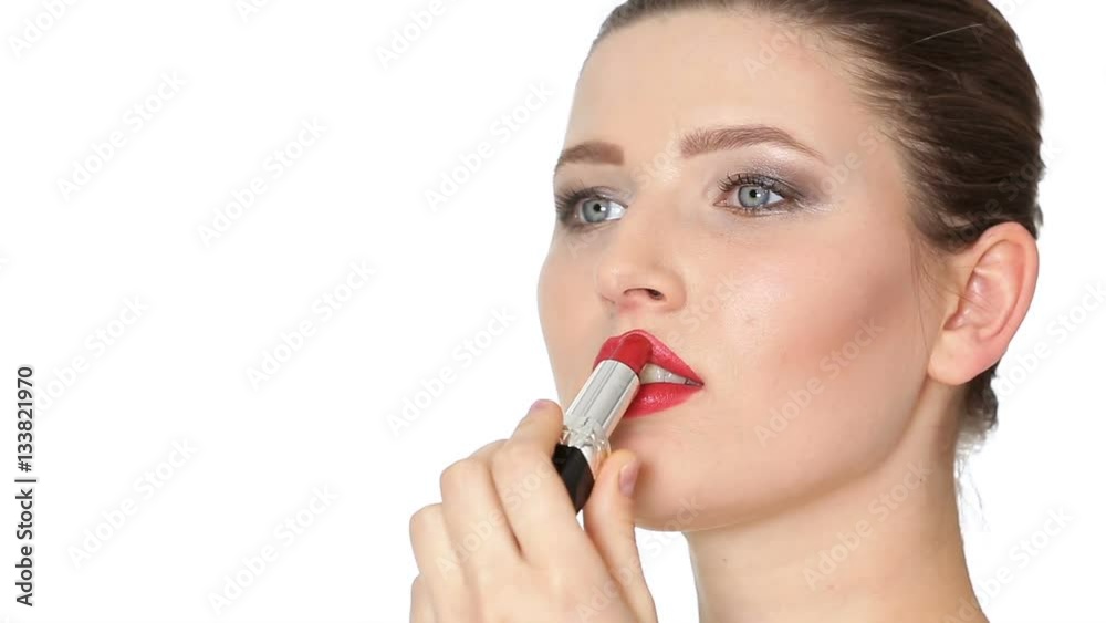 woman applying red lipstick on lips on white background. woman applying red lipstick on lips on white background.