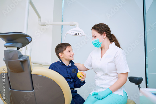 Doctor dentist and child handshake in the office. Dental treatment.
