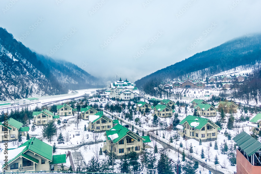 Cozy houses in snowy mountains. Krasnaya Polyana, Sochi, Russia