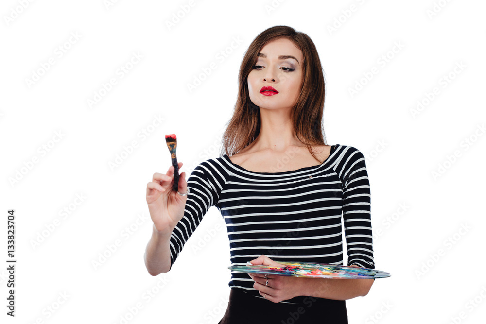 Cute beautiful girl artist holding a palette and brush in the process ...