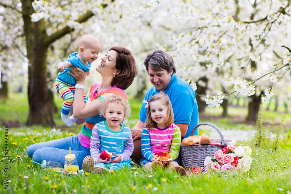 Fototapeta premium Family with children enjoying picnic in spring park