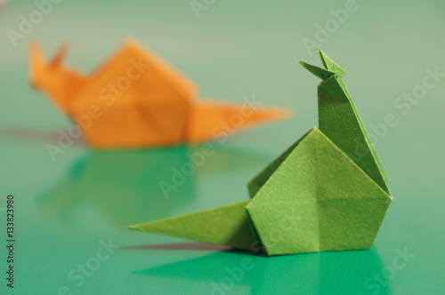 Paper origami snail isolated on a colorful background © romanklevets
