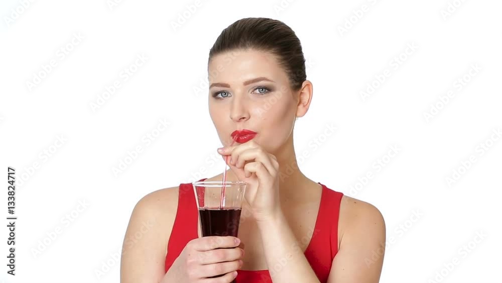 brunette woman drinking cherry juice from glass brunette woman drinking cherry juice from glass
