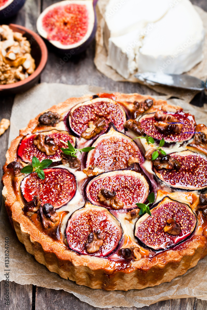 Delicious tart with fresh figs and goat cheese on rustic wooden Delicious tart with fresh figs and goat cheese on rustic wooden