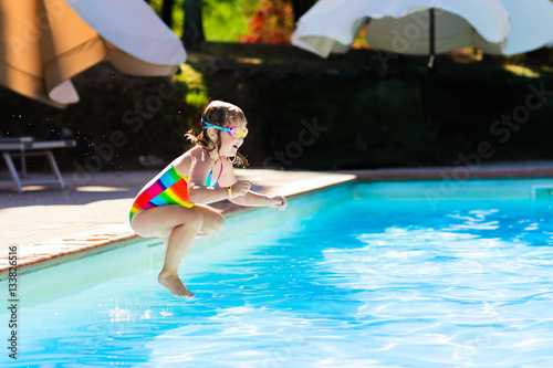 Little girl jumping into swimming pool