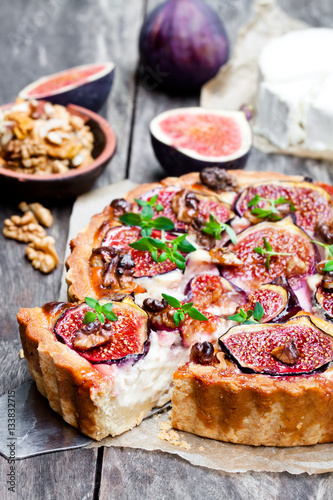 Delicious tart with fresh figs and goat cheese on rustic wooden