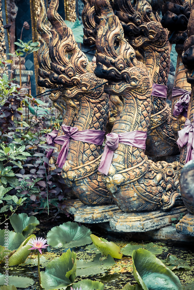 Sculptures of Buddhism deities in Asian style tropical garden