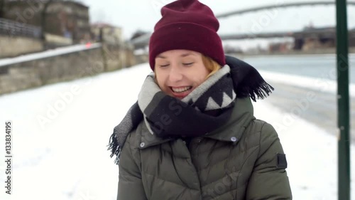 Happy girl standing outside and throwin snowball, steadycam shot
 photo