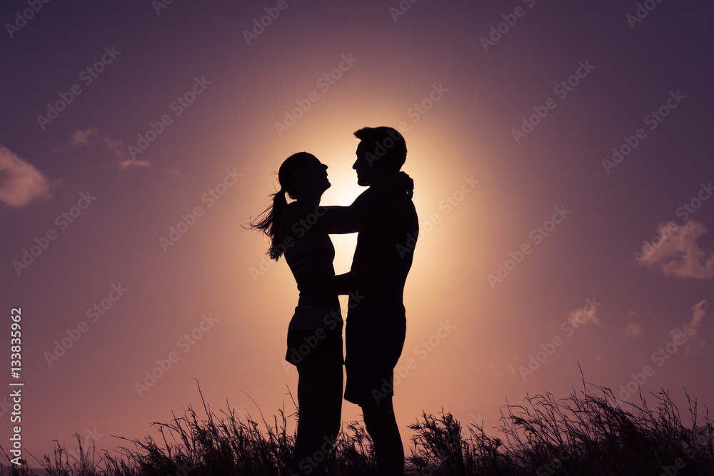 Love and relationships. Silhouette of man and woman hugging in the sunset. 