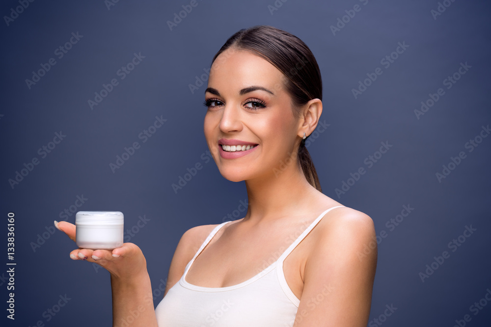 Skincare- Young woman holding cosmetic cream . Skincare- Young woman holding cosmetic cream .
