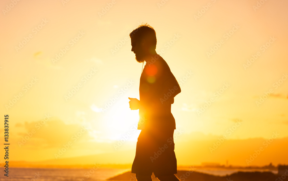 Male runner running in the sunset. 