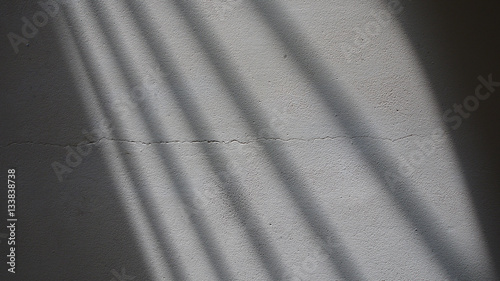 Grey Cracked Plaster Wall with Gate Shadow