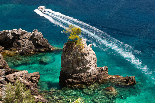 Landscape with azure clear sea with boat and rocks. Paleokastritsa. Near Liapades. Corfu (Kerkyra). Greece photo