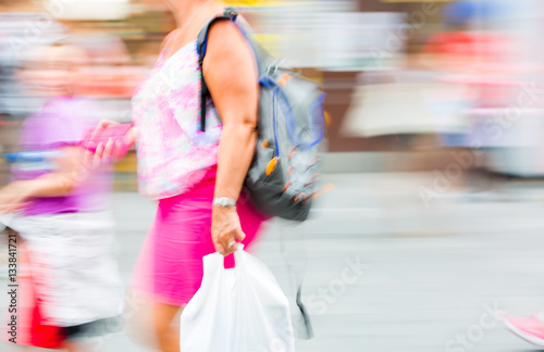 Blurred image of Young woman walking in the City. Londoners at warm summer day. UK 