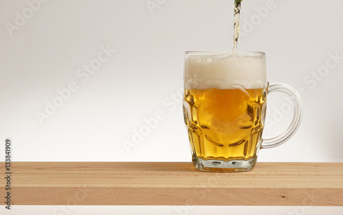 Glass of light beer on a wooden board. photo