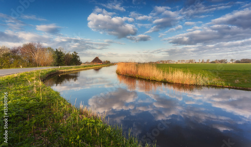 Bilde på lerret Buildings and trees near the water canal at sunrise in Netherlands