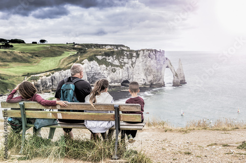 Family admires the scenery of the cliff of Etretat - Normandy - France