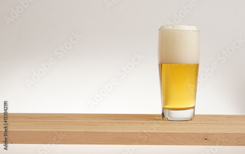 Glass of light beer on a wooden board. photo