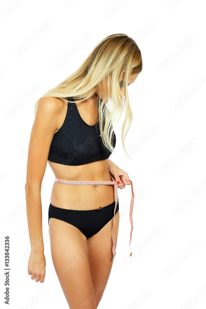Obraz premium Young attractive woman measuring her hips