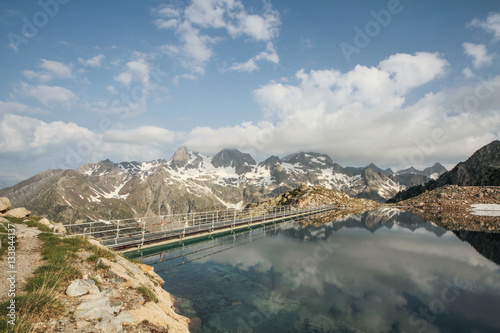 Lago de alta montaña o ibón con el cielo y las nubes reflejados en panticosa (Brazatos) en el pirineo aragonés photo