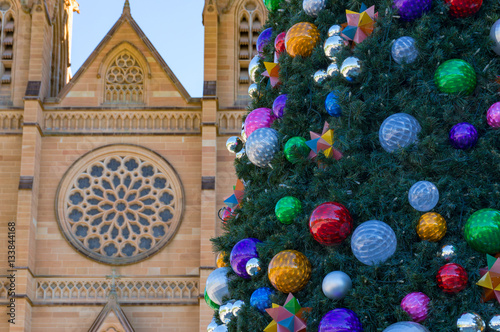 Christmas tree decorated with colourful baubles against sandston photo