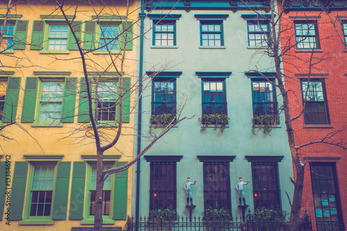 Charming row of colorful apartment building homes on quaint street in New York City with retro filter effect. photo