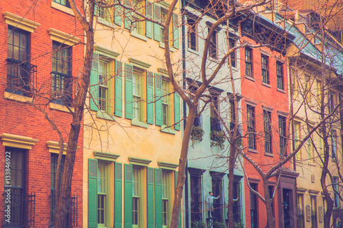Charming row of colorful apartment building homes on quaint street in New York City with retro filter effect. photo
